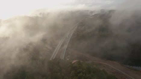 Drohnenaufnahmen-Von-Autobahnen-Und-Wohnsiedlungen-In-Norwegen-Mit-Etwas-Nebel-In-Der-Luft-Und-Sonne,-Die-Die-Wolken-Erhellt