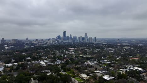 Aerial-view-approaching-the-Austin-city-skyline,-gloomy-autumn-day-in-Texas,-USA