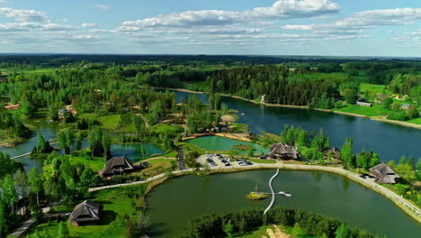 Luxury-resort-buildings-on-lake-coastline-surrounded-by-forest,-aerial-view