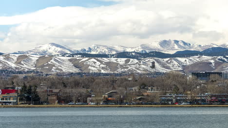 Time-lapse-of-the-Sloan-Lake-shoreline-in-Denver,-Colorado-with-snow-covered-Rocky-Mountains-in-the-background