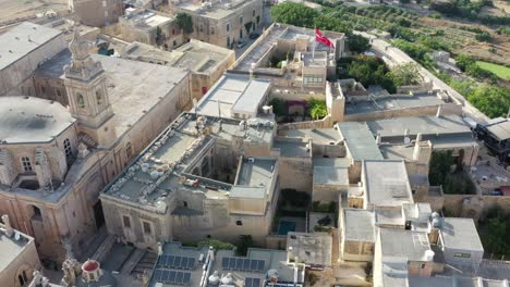 Flying-high-over-Malta's-Mdina-Fortress-city-revealing-landscape-and-horizon-in-the-background