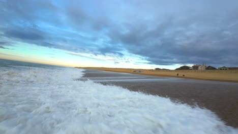 Low-altitude-fpv-flight-over-the-waves-at-the-surf-beach-of-Hossegor-during-a-cloudy-sunset