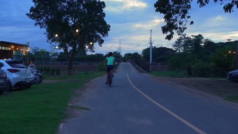 Eine-Junge-Asina-frau,-Die-Bei-Sonnenuntergang,-Thailand,-Die-Umgebung-Der-Provinz-Nan-In-Ihrem-Faltbaren-Fahrrad-Erkundet