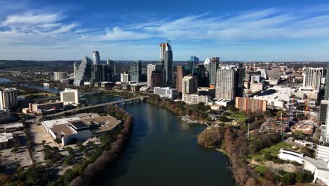 Aerial-view-of-the-river-and-riverside-buildings,-fall-foliage-in-sunny-Austin,-USA