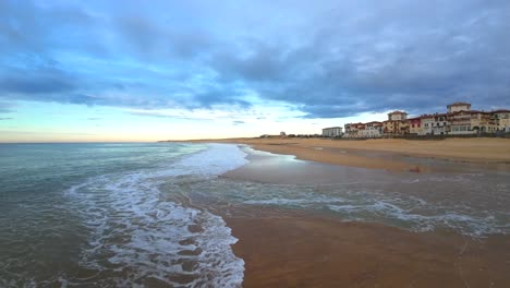 fpv-drone-flight-over-the-waves-at-the-surf-beach-of-Hossegor-during-a-cloudy-sunset