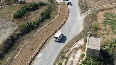 Aerial-Drone-Footage-Of-Car-On-Road-Towards-Wied-il-Għasri-In-Malta