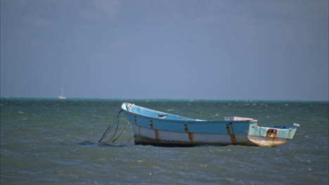 Slow-motion-of-an-old-rusty-boat-bloating-with-the-rhythm-of-the-waves-in-a-tranquil-day-at-the-sea