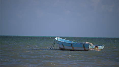 Zeitlupe-Eines-Alten-Rostigen-Fischerbootes,-Das-An-Einem-Ruhigen-Sonnigen-Tag-Im-Rhythmus-Der-Wellen-Im-Ozean-Schaukelt