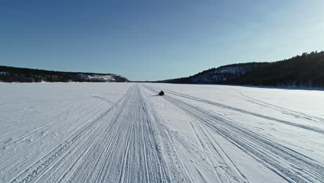 the-snowy-vast-landscape-of-Norway-Kirkenes-during-the-winter-season,-a-snowmobile-on-white-plain-snow-in-Norway