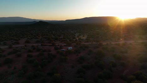 RV-On-The-Wild-Desert-With-Green-Bushes-In-Sedona,-Arizona-At-Sunset---aerial-drone-shot