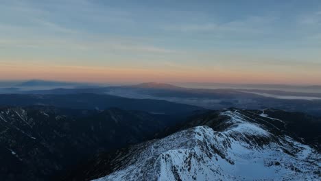 Drone-shot-from-Musala-peak-during-sunrise,-in-the-distance-you-see-Vitosha-mountain-and-foggy-Sofia,-Bulgaria,-highest-summit-on-the-Balkans,-golden-hour,-blue-hour,-dawn