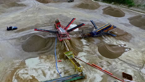Huge-open-pit-sand-and-gravel-mining-quarry---tilt-down-aerial-reveal