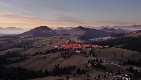 Aerial-panoramic-of-remote-village-on-a-hill-in-Transylvania-at-sunset