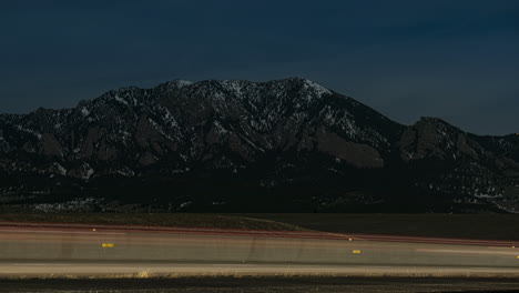 Time-lapse-of-cars-driving-by-the-Flatirons-near-Boulder,-Colorado-at-night-time