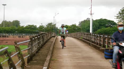 Una-Joven-Mujer-Asina-Explorando-Wiang-Sa-En-Su-Bicicleta-Plegable-Con-Casco-Por-Seguridad,-Tailandia,-Provincia-De-Nan