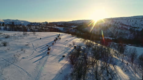 Luftbild-Von-Oben-Nach-Unten-Von-Husky-Schlittenhunden,-Die-Während-Des-Verschneiten-Wintertages-Bei-Sonnenuntergang-In-Norwegen-Schlitten-Ziehen