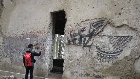 Man-touching-the-abandoned-hospital-wall-in-Sljeme,-Croatia