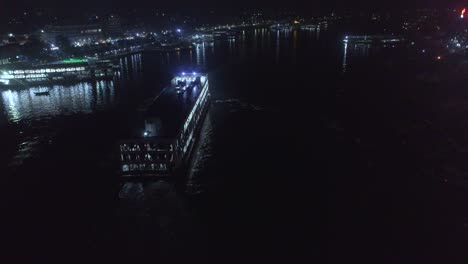 Toma-De-Drones-De-Un-Lanzamiento-Moviéndose-En-Un-Río-Por-La-Noche