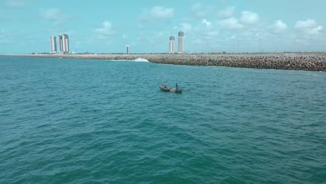 Victoria-Island-Lagos,-Nigeria---20-November-2022:-Drone-view-of-a-fisherman-on-a-fishing-boat-on-the-coastline-of-Lagos