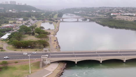 Aerial-drone-shot-along-the-Umgeni-bridge-crossing-the-Umgeni-river-mouth-in-South-Africa
