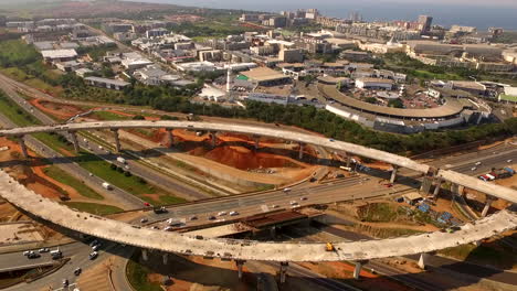 Aerial-drone-flyover-highway-interchange-construction-with-Gateway-Shipping-Mall-in-the-background