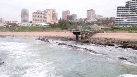 Wide-aerial-drone-shot-of-Umhlanga-pier,-lighthouse,-the-oysterbox-hotel-and-pearls-residences