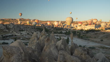 Aerial-View-From-Hot-Air-Balloon-of-Cappadocia-Landscape-and-Other-Parachutes-Flying-Above-at-Sunrise