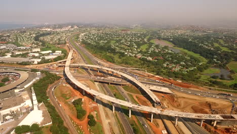 Hohe-Luftdrohne-über-Dem-Bau-An-Einem-Belebten-Autobahnkreuz,-Das-In-Südafrika-Gebaut-Wird