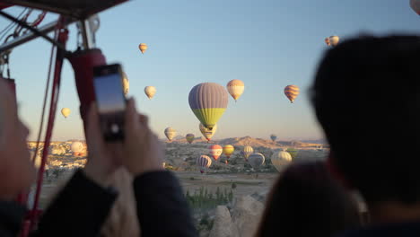 Touristen-Im-Korb-Fotografieren-Andere-Heißluftballons,-Die-über-Göreme,-Kappadokien,-Türkei,-Zeitlupe-Fliegen