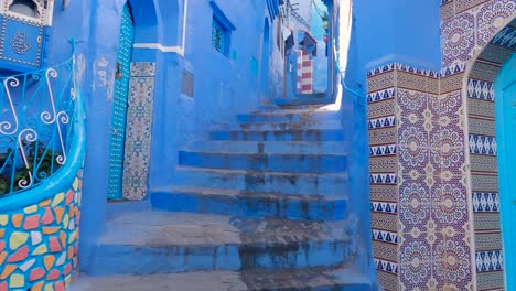 Subiendo-Escaleras-En-La-Pintoresca-Ciudad-Azul,-Chefchaouen,-Marruecos