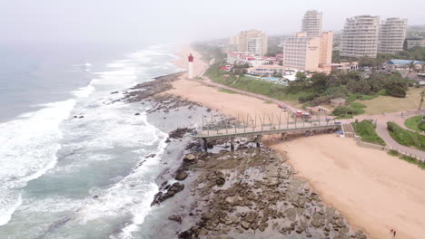 High-aerial-drone-shot-of-umhlanga-main-beach-with-the-pier-and-lighthouse