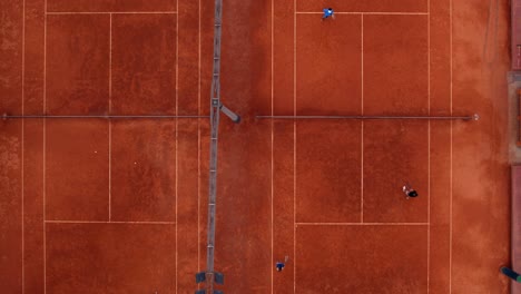 Overhead-Aufnahme-Von-Nebeneinander-Liegenden-Tennisplätzen,-Auf-Denen-Menschen-üben