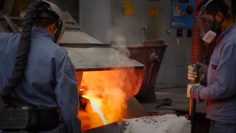 Men-pouring-liquid-metal-from-furnace---hot-like-fire