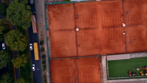 Overhead-Schuss-Von-Nebeneinander-Liegenden-Tennisplätzen-In-Der-Nähe-Einer-Belebten-Straße
