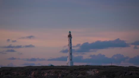 Sehen-Sie-Einen-Leuchtturm-Im-Zeitraffer-Bei-Sonnenuntergang-In-Aruba,-Ein-Leuchtfeuer,-Das-Die-Karibische-Küstenlandschaft-Erleuchtet