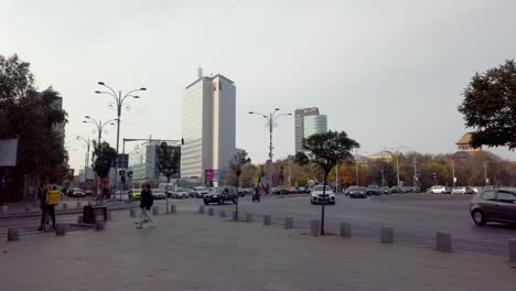 Victory-square-with-people-and-traffic,-Bucharest-Romania