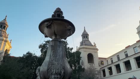 Fountain-inside-the-courtyard-of-Pasadena-City-Hall-at-sunset,-slow-motion-circle-view