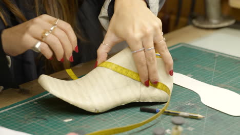 Female-measuring-size-of-foot-template-last-for-fashion-shoe-design-in-workshop