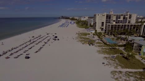 4K-Drone-Video-of-Beach-Cabanas,-Umbrellas,-and-Waterslide-on-the-Gulf-of-Mexico-in-St