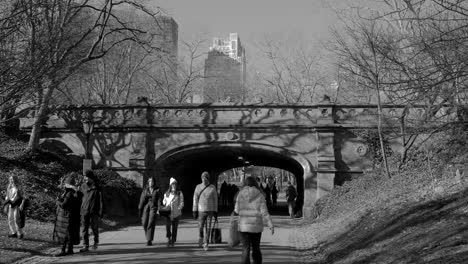 People-Walking-On-And-Beneath-The-Iconic-Driprock-Arch-Bridge-In-Central-Park,-New-York-City