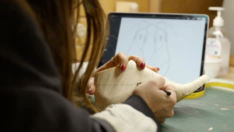 Mujer-Artesana-Dibujando-Un-Diseño-Creativo-En-La-Horma-De-La-Plantilla-En-La-Tableta-Ipad-Digital