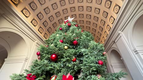 Orbit-motion-around-the-Christmas-tree-inside-Pasadena-City-Hall,-Look-up-at-Ornamented-ceiling