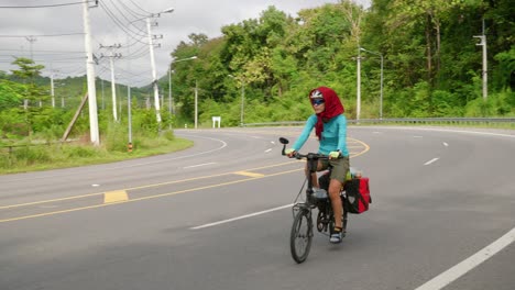 Mujer-Asiática-En-Bicicleta-Por-La-Carretera-En-Un-Viaje-Por-El-Sudeste-Asiático