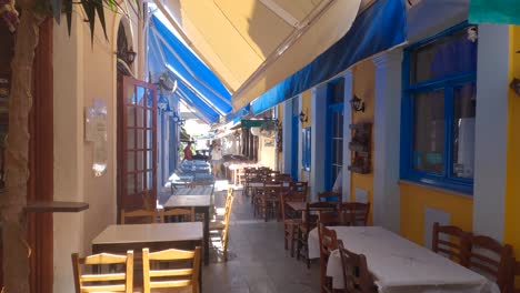 Narrow-street-with-typical-restaurants-in-Preveza,-Colorful-awnings-over-esplanade,-Greece