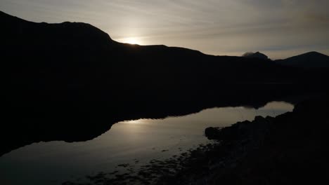 Der-Schatten-Eines-Berges-Spiegelt-Sich-Perfekt-Im-Stillen-Wasser-Eines-Schottischen-Sees-Bei-Sonnenuntergang