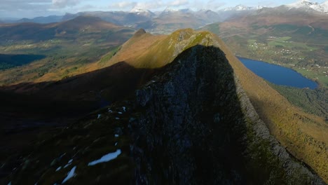 Spectacular-fpv-flight-over-green-idyllic-summits-of-mountain-range-in-Norway-with-lake-in-backdrop