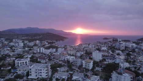 Aerial-Dolly-über-Ksamil-Riviera-Mit-Blick-Auf-Den-Atemberaubenden-Orangefarbenen-Sonnenuntergang-Am-Horizont