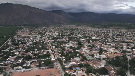 Aerial-Fly-Above-Cafayate-Town,-Salta,-Vineyards,-Scenic-Andes-Cordillera-Mountain-Landscape,-Wine-Production-Travel-and-Tourism-in-Argentina,-South-America