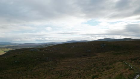 Ein-Langsamer-Schwenk-Zeigt-Langsam-Eine-Helle-Landschaft-Mit-Bergen-Und-Lochs-Im-Nordwestlichen-Hochland-Von-Schottland,-Während-Licht-Den-Bewölkten-Himmel-In-Der-Ferne-Durchdringt