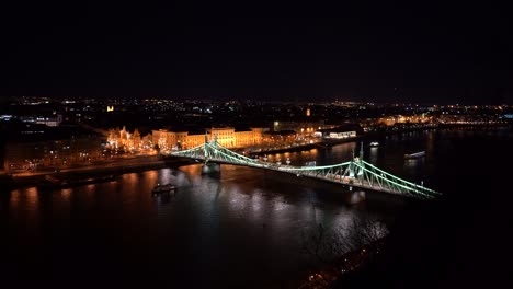 Vida-Nocturna,-Paisaje-Urbano-Con-Un-Puente-En-Budapest,-Barco-En-El-Río